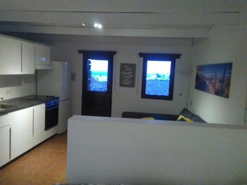 a kitchen with white cabinets and a counter top at Loft La Tahonilla in Tías