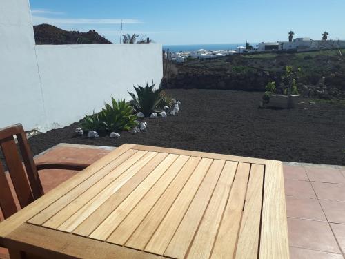 a wooden table on a patio with a view of the ocean at Loft La Tahonilla in Tías
