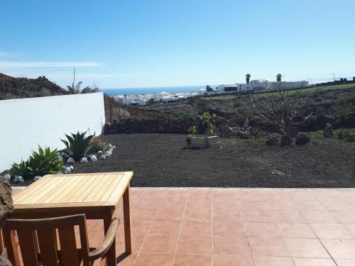 a patio with a wooden table and chairs and the ocean at Loft La Tahonilla in Tías