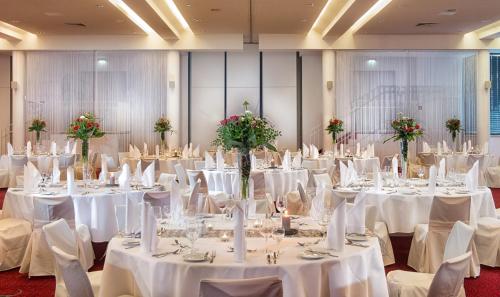 a banquet hall with white tables and chairs at Radisson Blu Park Hotel & Conference Centre in Dresden