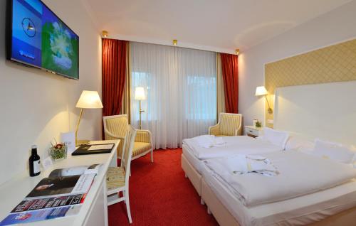Habitación de hotel con 2 camas y escritorio en Ringhotel Landhaus Gardels en Sankt Michaelisdonn