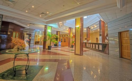 a lobby with a table in the middle of a building at Tsokkos Gardens Hotel in Protaras