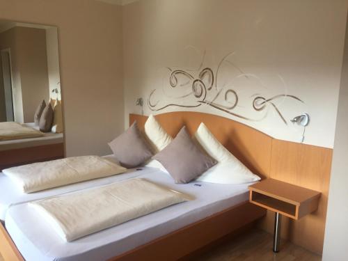 a bedroom with two beds with a headboard and a mirror at Pension Wagner in Ingolstadt