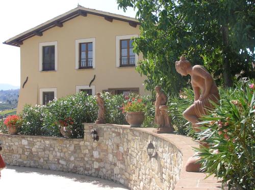 a statue of people standing on a wall in front of a house at Genius Loci Country Inn in Bevagna