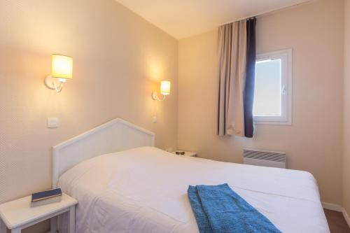 a small bedroom with a white bed and a window at Résidence Pierre & Vacances Le Thabor in Valmeinier