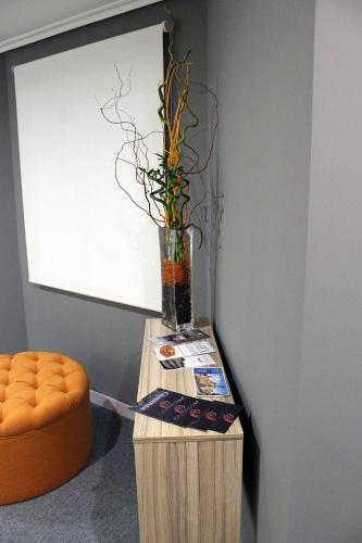 a table with a vase with a plant in it at Hotel Altiana in Ourense