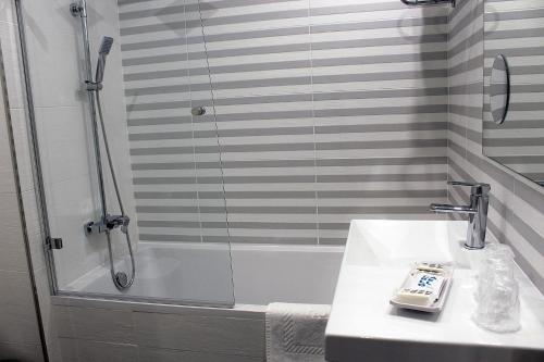 a bathroom with a shower and a sink at Hotel Altiana in Ourense