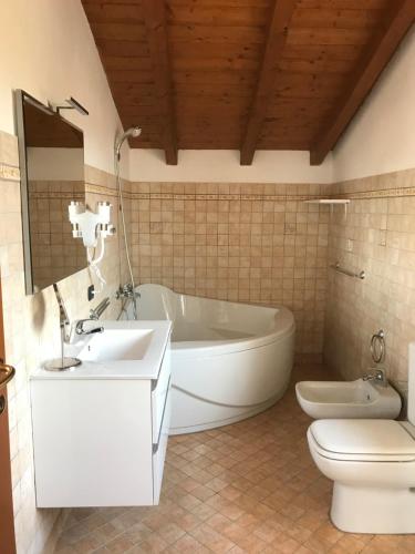 y baño con bañera, lavabo y aseo. en Color House Malpensa B&B, en Cassano Magnago