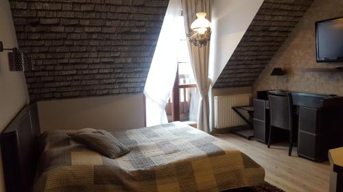 1 dormitorio con cama y pared de ladrillo en Apartament 30 Angel - Pod Aniołem en Kazimierz Dolny