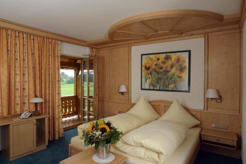 a living room with a couch and a vase of flowers at Landhotel Hoisl-Bräu in Penzberg
