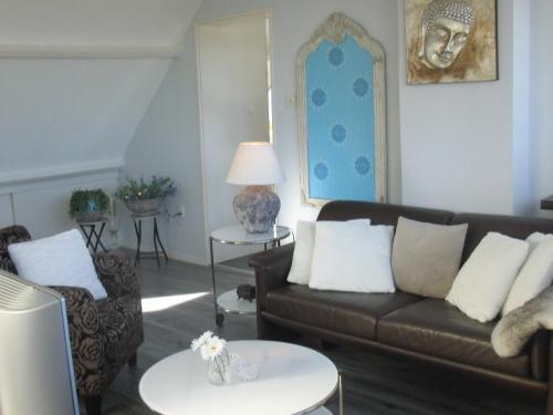 a living room with a couch and a table at Huize de Weijde Blick in Wijk aan Zee
