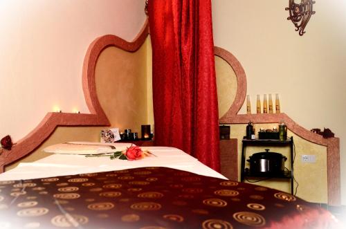 Casa vacanze da Francesca في كالا غونوني: غرفة نوم بسرير وستارة حمراء