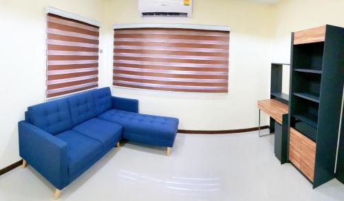 a living room with a blue couch and a television at Walking Street Residence - Boutique Suites near the Beach & Walking Street in Pattaya South