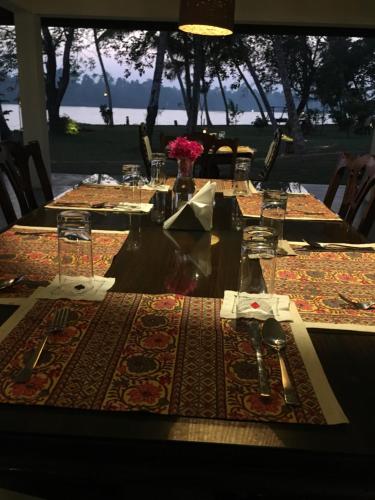 a long table with plates and utensils on it at Cranganor History Café & Riverside Château in Parūr