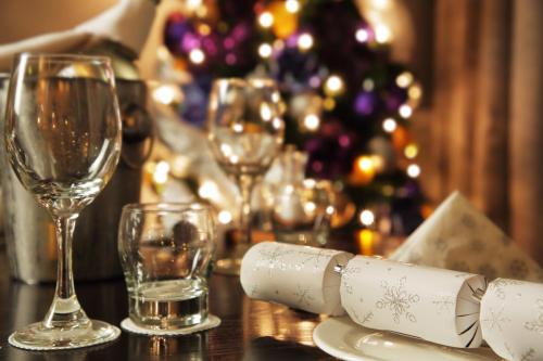 a table with wine glasses and a christmas tree at Trout Hotel in Cockermouth