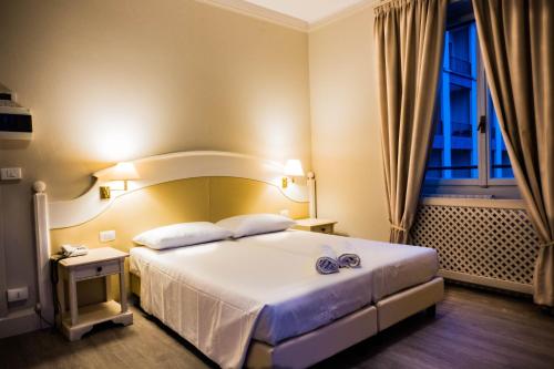 ein Hotelzimmer mit einem Bett und einem Fenster in der Unterkunft Hotel Bazzoni in Tremezzo