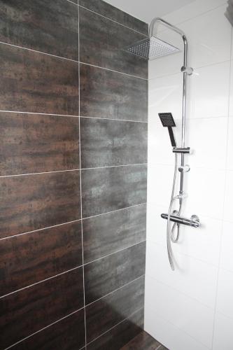 a bathroom with a shower with wooden tiles at Apartment Caplex in Oldenburg