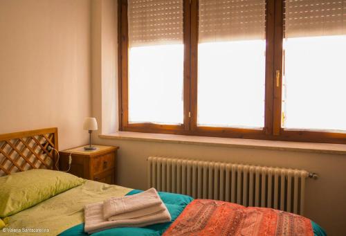 Un dormitorio con una cama con dos ventanas y un radiador. en Casa Jacquard, en Schio