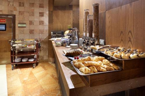 a kitchen filled with lots of different types of pastries at Eurostars Suites Mirasierra in Madrid