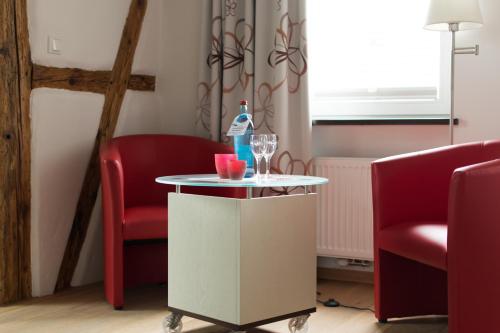 a room with two chairs and a table with a bottle and glasses at Wein-Domizil Brennofen in Ilbesheim