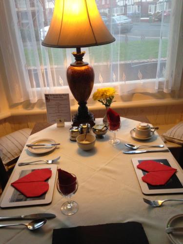 une table avec une lampe au-dessus d'une table dans l'établissement The Waverley Guest House, à Whitby