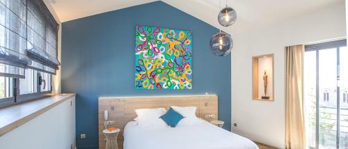 a bedroom with a bed with a painting on the wall at Hotel De France in Valence