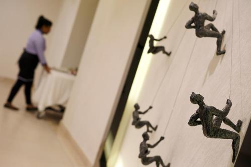a man walking past a wall with toy figurines on it at Mercure Chennai Sriperumbudur in Sriperumbudur