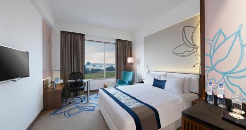 a hotel room with a bed and a desk and a tv at Mercure Chennai Sriperumbudur in Sriperumbudur