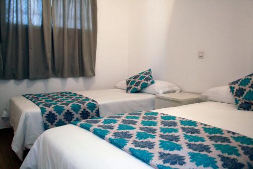 a hotel room with two beds and a window at Apartamentos Guanarama in Puerto del Carmen