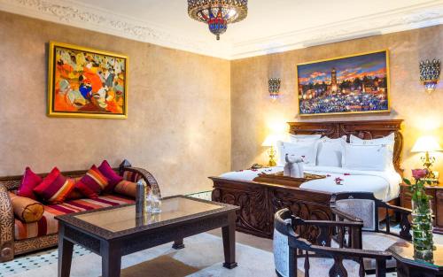 a hotel room with a bed and a couch at Hivernage Secret Suites & Garden in Marrakech