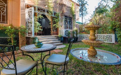 a patio with a table and chairs and a fountain at Hivernage Secret Suites & Garden in Marrakech