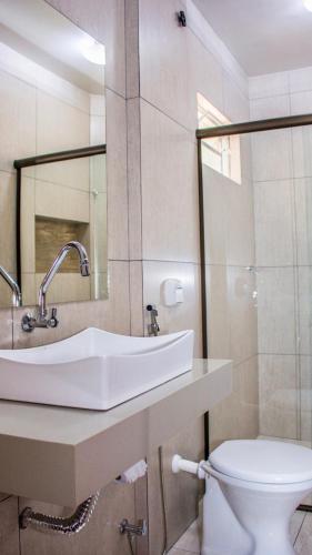 a bathroom with a sink and a toilet at Hotel Paradizzo in Foz do Iguaçu