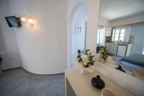 a living room with a sink and a room with a bed at Ianthe Apartments & Villa in Oia