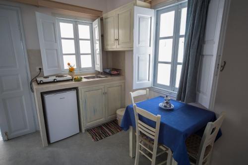 a kitchen with a table with a blue table cloth at Ianthe Apartments & Villa in Oia