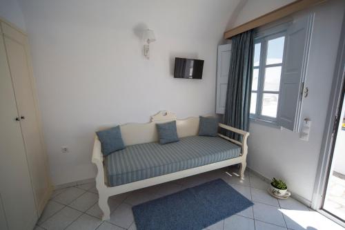 a bench sitting in a room with a window at Ianthe Apartments & Villa in Oia