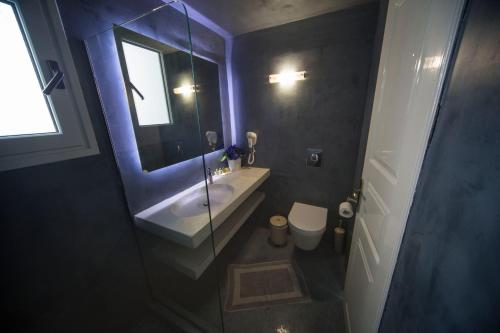 a small bathroom with a sink and a mirror at Ianthe Apartments & Villa in Oia