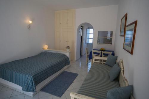 a bedroom with a bed and a chair in it at Ianthe Apartments & Villa in Oia