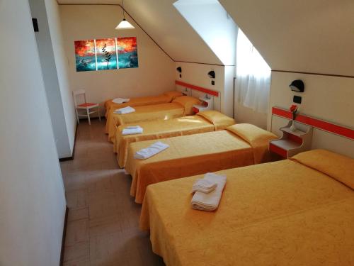 eine Gruppe von Betten in einem Zimmer mit orangefarbenen Betten in der Unterkunft Hotel Devon Rooms & Breakfast in Cesenatico