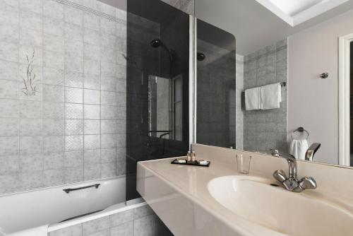 a bathroom with a sink and a mirror at Résidence du Pré in Paris