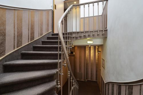 a spiral staircase in a building with a stair case at Résidence du Pré in Paris