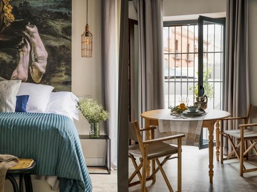 een slaapkamer met een bed en een tafel en een eetkamer bij Matahacas Pool & Luxury in Sevilla