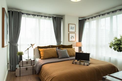 a bedroom with a bed with a laptop on it at Budget 2 bedrooms Apartment in Huahin in Hua Hin