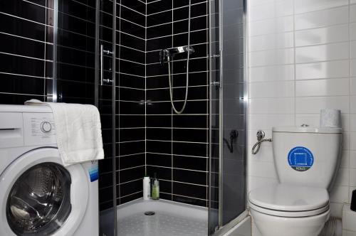 a bathroom with a toilet and a washing machine at Prudentia Apartments Jana Kazimierza in Warsaw