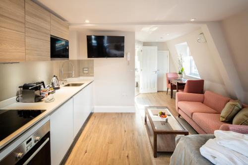 a kitchen and living room with a couch and a table at Beech House - Urban Apartments in Bristol