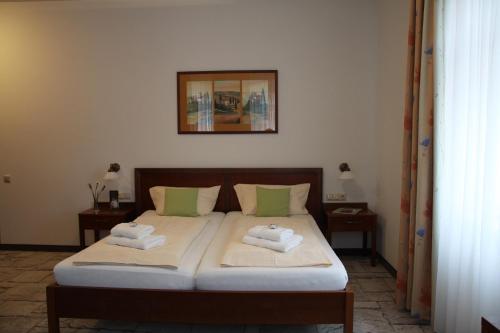 1 dormitorio con 1 cama con 2 toallas en Hotel-Restaurant 1735, en Speyer