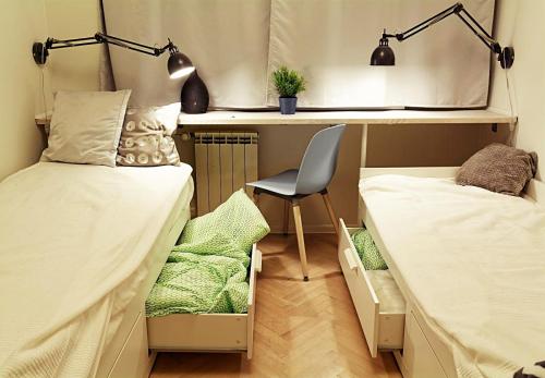 グディニャにあるApartament na Wzgórzuのベッドルーム1室(ベッド2台、デスク、椅子付)