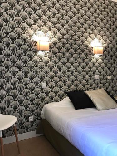 a bedroom with a large bed and a wall at Hôtel De La Loge in Perpignan