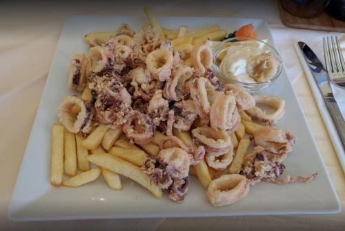 a plate of pasta and french fries on a table at Apartments and Rooms Lucia&Veronica in Dramalj