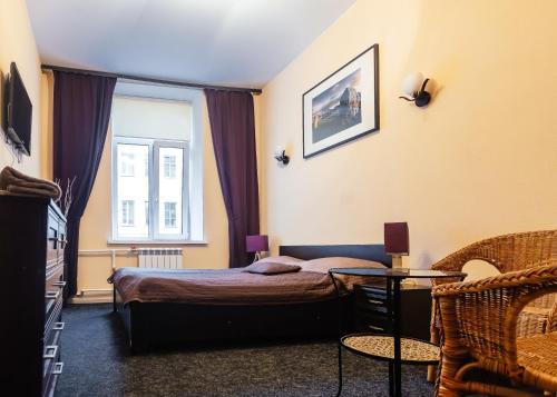 a bedroom with a bed and a table and a window at Mini Hotel na Nevskom 136 in Saint Petersburg