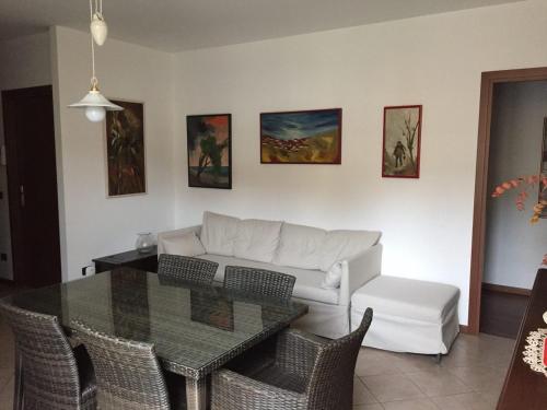 ein Wohnzimmer mit einem weißen Sofa und einem Tisch in der Unterkunft Casa Girasole in Fino Mornasco